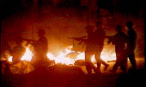 Soliders walking alongside a wall of fire